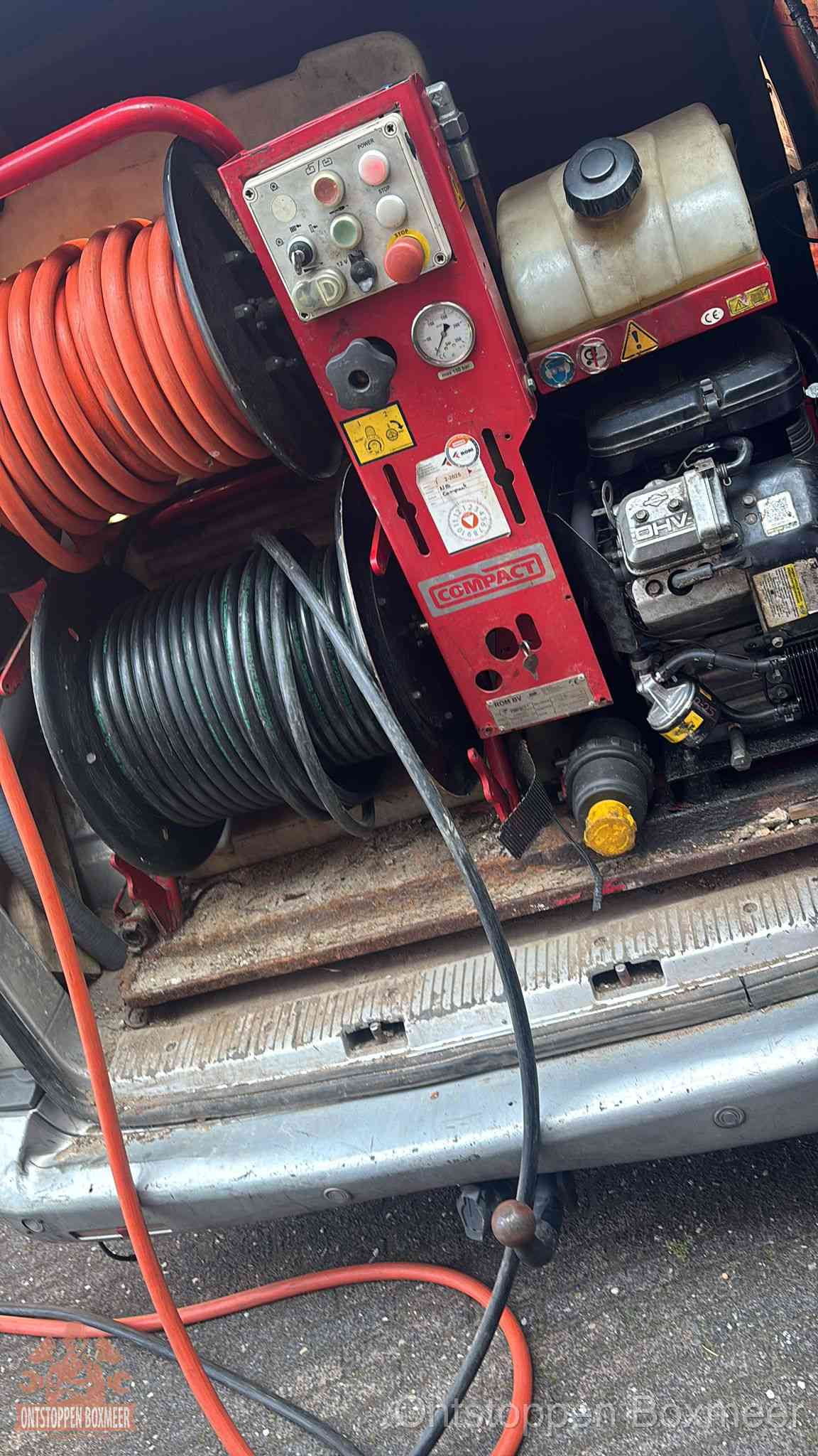 Een rood hogedruk-rioolreinigingstoestel met slangen in de laadbak van de bedrijfsbus, apparatuur voor een hardnekkige wc-verstopping in Boxmeer Een rood hogedruk-rioolreinigingstoestel met slangen in de laadbak van de bedrijfsbus, apparatuur voor een hardnekkige wc-verstopping in Boxmeer