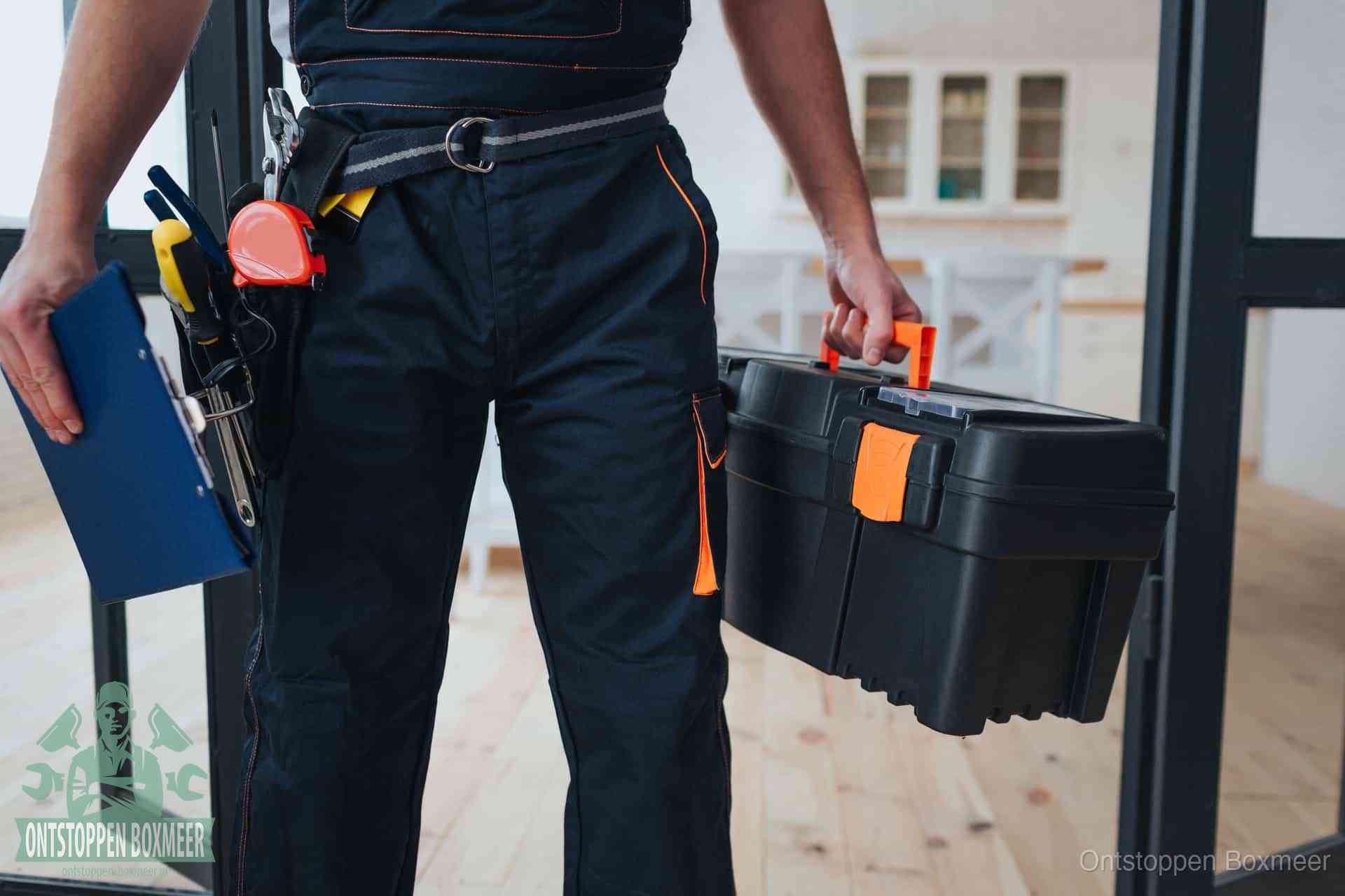 Een monteur met gereedschapsriem en klembord, klaar om een transparante prijs voor het afvoer ontstoppen in Boxmeer te geven