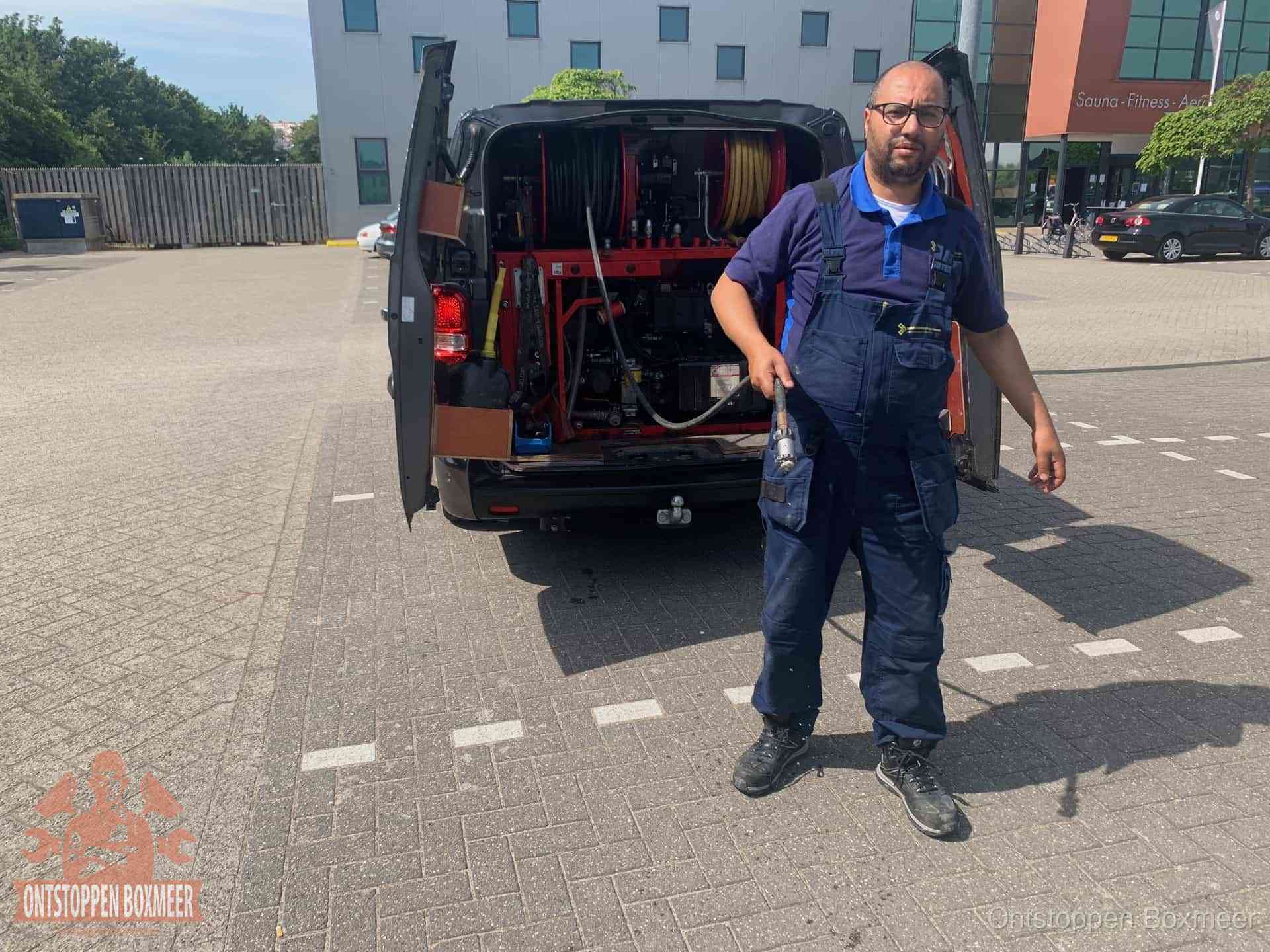 Een monteur bij zijn bestelbus met een hogedruk- en rioolreinigingsunit, klaar om de oorzaak van terugkerende wc-verstoppingen aan te pakken in Boxmeer Een monteur bij zijn bestelbus met een hogedruk- en rioolreinigingsunit, klaar om de oorzaak van terugkerende wc-verstoppingen aan te pakken in Boxmeer