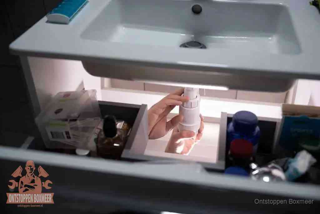Een pompfles met zeep boven een wastafel in de toiletruimte, de warm water en afwasmiddel-methode om de wc te ontstoppen in Boxmeer Een pompfles met zeep boven een wastafel in de toiletruimte, de warm water en afwasmiddel-methode om de wc te ontstoppen in Boxmeer