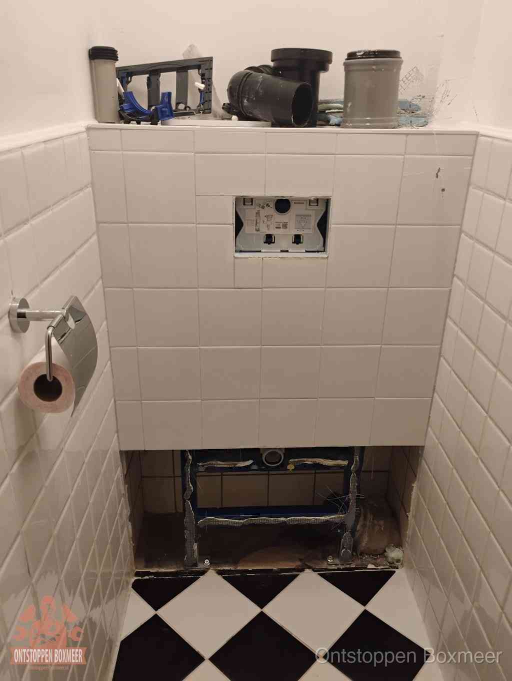 Een toiletruimte waar het hangtoilet en de inbouwreservoir-onderdelen zijn vrijgelegd voor onderhoud, periodiek nazicht voorkomt een wc-verstopping in Boxmeer Een toiletruimte waar het hangtoilet en de inbouwreservoir-onderdelen zijn vrijgelegd voor onderhoud, periodiek nazicht voorkomt een wc-verstopping in Boxmeer